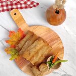 Spring Rolls lumpia on the wooden tray with white table
